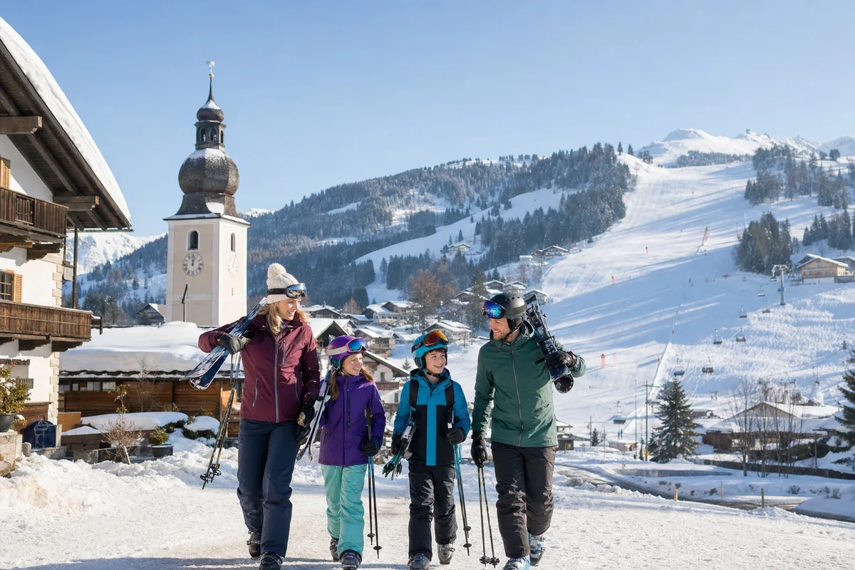 Familj på väg till backen i en österrikisk alpby